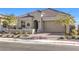 One-story home with tan exterior and landscaped yard at 56 Tatahatso Point St, Henderson, NV 89011