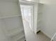 Walk-in closet with built in shelves, white walls, and light wood flooring at 7255 W Sunset Rd # 2046, Las Vegas, NV 89113