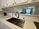 Modern kitchen sink with white countertops and view to living area at 2056 Mesquite Ln # 303, Laughlin, NV 89029
