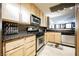 A view of the kitchen with stainless steel microwave and stove, dishwasher and wood cabinets at 230 E Flamingo Rd # 212, Las Vegas, NV 89169