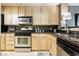 Well-lit kitchen features stainless steel appliances, light wood cabinetry, and dark countertops at 230 E Flamingo Rd # 212, Las Vegas, NV 89169