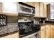 A close view of a stainless steel microwave and stove with black and dark countertops at 230 E Flamingo Rd # 212, Las Vegas, NV 89169