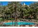 Beautiful pool area surrounded by lush greenery, palm trees, and lounge chairs, creating a relaxing oasis at 230 E Flamingo Rd # 212, Las Vegas, NV 89169