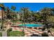 Beautiful pool area surrounded by palm trees, lounge chairs, and a checkered patio, perfect for outdoor enjoyment at 230 E Flamingo Rd # 212, Las Vegas, NV 89169