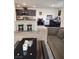 Open-concept living space with bar stool seating and modern kitchen in the background at 2657 Champagne Gold Ave, North Las Vegas, NV 89086