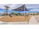 Shaded playground area with a slide, climbing structures, and protective wood chip ground cover at 2657 Champagne Gold Ave, North Las Vegas, NV 89086