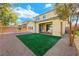 Backyard with artificial turf, covered patio, and landscaping at 3094 Isle Dr, Las Vegas, NV 89141