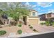 Two-story house with tan exterior, brick driveway, and landscaping at 3094 Isle Dr, Las Vegas, NV 89141