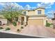 Two-story house with tan exterior, brick driveway and landscaping at 3094 Isle Dr, Las Vegas, NV 89141