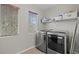 Bright laundry room with washer, dryer, and shelving at 8027 Carr Valley St, Las Vegas, NV 89131