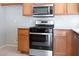 Kitchen featuring wooden cabinets, modern appliances, and tile backsplash at 3591 Driving Range St, Las Vegas, NV 89122