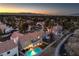 Aerial view of house with pool and desert landscaping at sunset. City views at 18 Tarryall Ter, Henderson, NV 89074