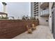 Private condo balcony featuring brick wall, two tan wicker chairs, and tile floor, with city views at 200 W Sahara Ave # 601, Las Vegas, NV 89102