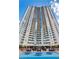 Striking exterior view of a high-rise building with balconies overlooking the pool and lounge area with blue cushions at 200 W Sahara Ave # 601, Las Vegas, NV 89102