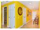 Hallway with yellow walls has tile flooring, multiple doors, and a round mirror on the wall at 200 W Sahara Ave # 601, Las Vegas, NV 89102