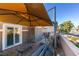 Relaxing outdoor patio with comfortable seating, shade umbrella, and stylish stone accent wall at 2817 High View Dr, Henderson, NV 89014