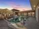 A luxurious pool and spa area with a tiki hut and elegant lighting at dusk at 2817 High View Dr, Henderson, NV 89014