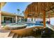 Relaxing pool and spa with a tiki hut, bar stools, and outdoor living space at 2817 High View Dr, Henderson, NV 89014