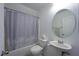 This is a clean bathroom with a shower and tub combination and large round mirror at 4920 Blue Rose St, North Las Vegas, NV 89081