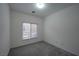 An interior shot of a bedroom with gray carpet and a window with blinds at 4920 Blue Rose St, North Las Vegas, NV 89081