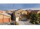 Two-story home showcasing a 3-car garage, shutters, and neutral color palette under a bright blue sky at 4920 Blue Rose St, North Las Vegas, NV 89081