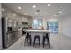 Modern kitchen featuring stainless steel appliances, a center island with seating, and ample natural light at 4920 Blue Rose St, North Las Vegas, NV 89081