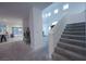 Inviting living space with a staircase, bright windows, and a peek into the modern kitchen at 4920 Blue Rose St, North Las Vegas, NV 89081