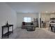 Bright living room with neutral tones, a comfortable sofa, and seamless connection to the kitchen at 4920 Blue Rose St, North Las Vegas, NV 89081