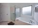 The main bathroom has a bathtub with a glass shower door and a privacy window at 4920 Blue Rose St, North Las Vegas, NV 89081