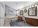 Bright bathroom featuring double sinks, granite countertops, soaking tub, and modern fixtures at 5944 Vizzi Ct, Las Vegas, NV 89131