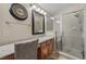 Bright bathroom featuring a large mirror, modern fixtures, vanity and glass-enclosed shower at 5944 Vizzi Ct, Las Vegas, NV 89131