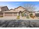 Beautiful home exterior with well-manicured landscaping and a three-car garage at 5944 Vizzi Ct, Las Vegas, NV 89131