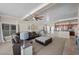 Inviting living room featuring a ceiling fan, a large window, and view into kitchen at 5944 Vizzi Ct, Las Vegas, NV 89131