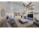 Open-concept living space featuring a fireplace, ceiling fan, and kitchen with granite countertops at 5944 Vizzi Ct, Las Vegas, NV 89131