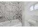 Clean bathroom with a bathtub, toilet, and marble tile at 112 Joshua St, Henderson, NV 89015