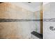 Walk-in shower with tiled walls, mosaic details, and built-in bench at 12002 Tramonto Ave, Las Vegas, NV 89138