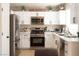 Modern kitchen featuring white cabinets, stainless steel appliances, and quartz countertops at 2179 Point Mallard Dr, Henderson, NV 89012