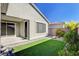 Well-maintained backyard with artificial grass, lush landscaping, and a private patio area at 2391 Dalewood Ave, North Las Vegas, NV 89086