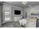 Spacious bedroom with plush gray carpet, a large TV, and access to the bathroom and backyard at 2391 Dalewood Ave, North Las Vegas, NV 89086