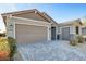 Stylish single-story home featuring a three-car garage, desert landscaping, and a modern driveway at 2391 Dalewood Ave, North Las Vegas, NV 89086
