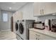 Well-equipped laundry room with modern washer and dryer, ample cabinet space, and sleek countertops at 2391 Dalewood Ave, North Las Vegas, NV 89086