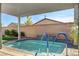 Inviting covered pool area with ladders and a tranquil waterfall feature at 2391 Dalewood Ave, North Las Vegas, NV 89086
