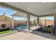 Inviting covered pool area with a tranquil waterfall feature and lounge area at 2391 Dalewood Ave, North Las Vegas, NV 89086