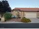 Charming single-story home with a well-maintained yard and desert landscaping, including mature trees and flowering bushes at 5048 Orchid Springs St, Las Vegas, NV 89148