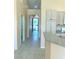 Hallway with neutral walls and tile floor leading to the exterior with a view of the entrance and sun screen door at 5048 Orchid Springs St, Las Vegas, NV 89148