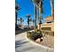 Picturesque community entrance with lush landscaping, sidewalks, and palm trees at 5048 Orchid Springs St, Las Vegas, NV 89148
