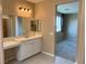 Bathroom vanity with neutral countertops, stylish lighting, double mirrors, and an attached seating area at 11467 Monte Isola St, Las Vegas, NV 89141