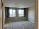 Neutral bedroom with two windows featuring dark curtains and natural light at 11467 Monte Isola St, Las Vegas, NV 89141