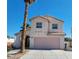 Two-story house with a pink garage door and a palm tree in the front yard at 5402 Night Swim Ln, Las Vegas, NV 89113