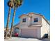 Two-story house with a pink garage door and two palm trees at 5402 Night Swim Ln, Las Vegas, NV 89113